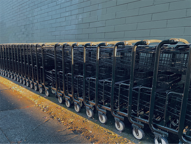 row of shopping carts against grey wall